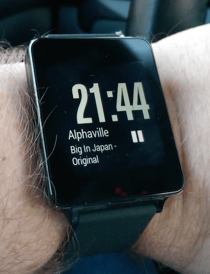 LG Watch "inaktiv" mit abgedunkeltem Bildschirm. Aktuell gespielter Song von Spotify wird angezeigt und kann pausiert werden. 